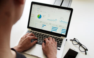 A close-up photo of a laptop screen displaying complex charts and graphs, representing in-depth analysis of data and trends in the California commercial real estate market.