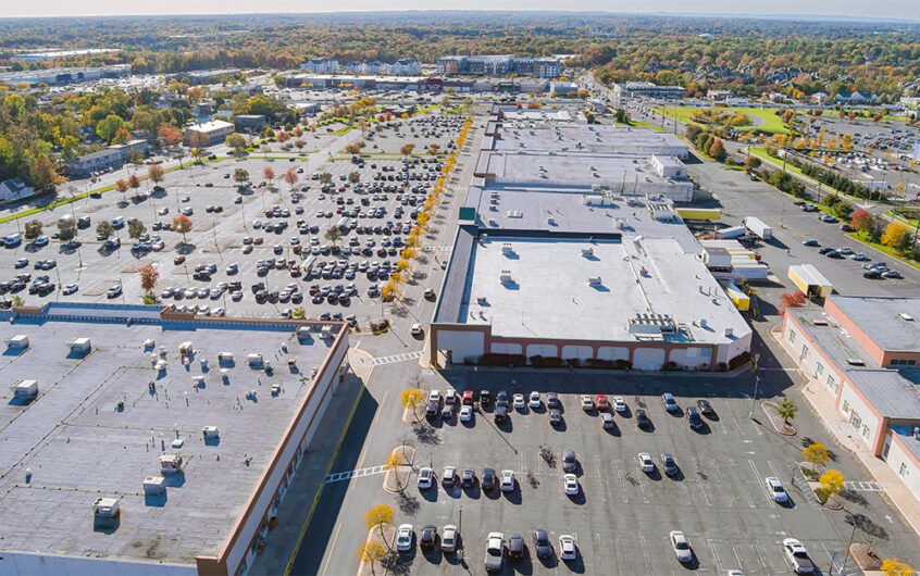 Busy shopping center with full parking lot representing retail growth and economic development in a thriving community.