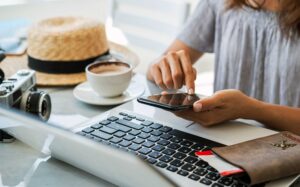 Traveler planning a trip on mobile device and laptop, representing search optimization for tourism and AI-powered travel planning